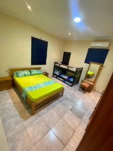 Un dormitorio con una cama verde y una silla en La Casona 42, en Barranquilla