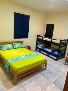 a bedroom with a green bed and a black shelf at La Casona 42 in Barranquilla