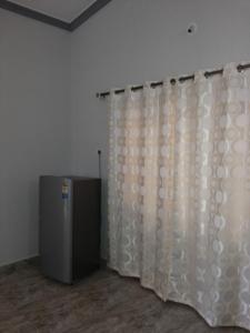 カンドリムにあるJason Guest Houseのシャワーカーテンと冷蔵庫のある部屋