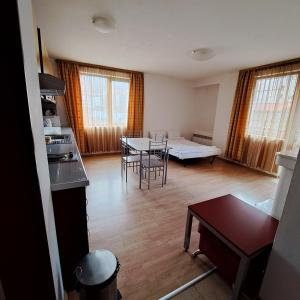 a living room with a table and chairs in it at Todorini Kuli Apartments in Bansko