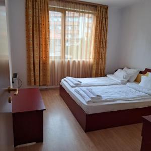 1 dormitorio con 2 camas y ventana en Todorini Kuli Apartments, en Bansko