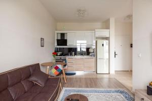 a living room with a brown couch and a kitchen at ixi in Tbilisi City