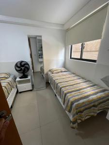 1 dormitorio con 2 camas y ventana en Flat no Cabo Branco, en João Pessoa