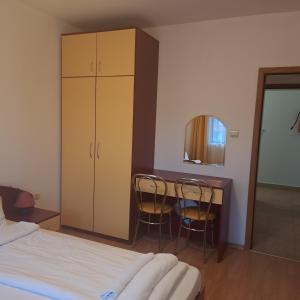 1 dormitorio con 1 cama y escritorio con 2 sillas en Todorini Kuli Apartments, en Bansko