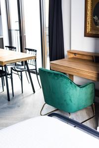 a green chair in a room with tables and chairs at Le Black & White - Vieux-Terrebonne in Terrebonne