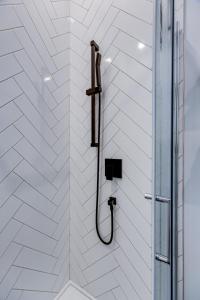 eine Dusche mit einem Schlauch in einer weißen Wand in der Unterkunft Le Black & White - Vieux-Terrebonne in Terrebonne