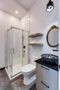 a bathroom with a shower and a toilet and a sink at Le Black & White - Vieux-Terrebonne in Terrebonne