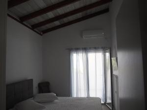 a bedroom with a bed and a window at Bianco e Azzuro in Vouliagmeni Lake