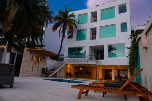 un edificio con piscina y un banco frente a él en Hotel Caribbean Cartagena en Cartagena de Indias