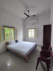 1 dormitorio con 1 cama y 1 silla en Hotel Padma Shree , Madurai - Near Airport en Madurai