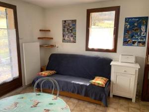 een woonkamer met een blauwe bank en een tafel bij Chalet Pastel in Morillon