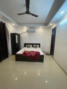 sypialnia z łóżkiem i wentylatorem sufitowym w obiekcie Own Stay w Nowym Delhi