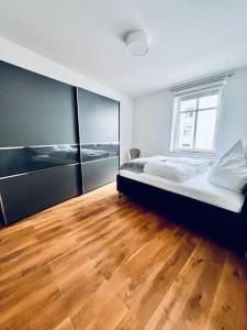 een slaapkamer met een bed en een houten vloer bij Mi Casa 3 Zimmer geschmackvoll zentral in Bremen in Bremen