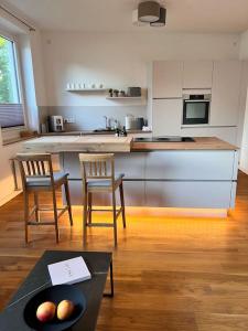 een keuken met twee stoelen en een tafel met fruit erop bij Mi Casa 3 Zimmer geschmackvoll zentral in Bremen in Bremen