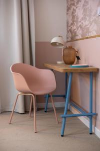 a pink chair next to a table with a lamp at Willa Zalesie in Krynica Zdrój