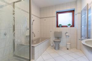 a bathroom with a tub and a toilet and a sink at Haus zur alten Mühle in Sankt Peter-Ording +26 photos