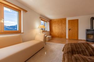 a bedroom with a bed and a large window at Chalet Casa Acla Laax in Laax