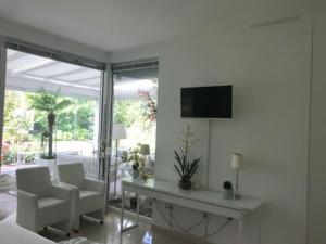 a living room with a table and chairs and a television at Ferienhaus am Lünner See in Lünne