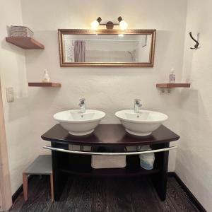 a bathroom with two sinks and a mirror at Sweet Alpen Home in Garmisch-Partenkirchen +23 photos