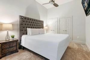 um quarto branco com uma cama grande e uma cabeceira preta em Signature Condo in the Heart of Downtown New Orleans em Nova Orleans