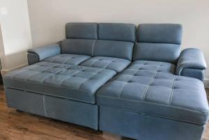 um sofá de couro azul numa sala de estar em Signature Condo in the Heart of Downtown New Orleans em Nova Orleans