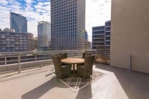 uma mesa e cadeiras numa varanda com vista para o horizonte da cidade em Signature Condo in the Heart of Downtown New Orleans em Nova Orleans