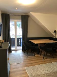 a dining room with a table and chairs and a window at Appartement Sonnenstrahl Ferienhaus Fuenf Sinne in Döbriach