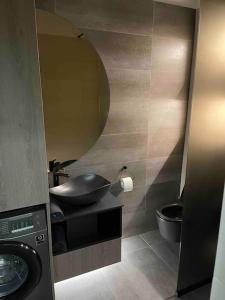 a bathroom with a sink and a toilet and a mirror at ATH Modern Homes - Luxury Apartment in the City Center in Iaşi