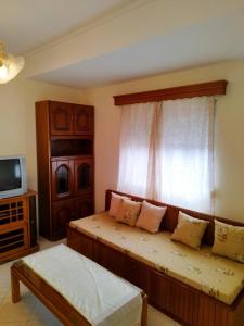 Habitación con cama, ventana y TV. en Zoi Country Home by Eutopia en Ioánina