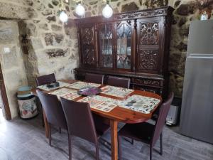 a dining room table with chairs and a wooden cabinet at Casa Rural Area con piscina in Gondomar