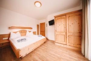 een slaapkamer met een bed en een grote houten kast bij Posers Bergwelt in Schladming