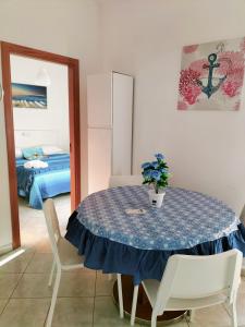 een eettafel met een blauw tafelkleed en witte stoelen bij I 23 PASSI Marina di Minturno in Minturno