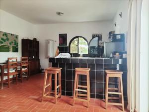 a kitchen with two bar stools and a counter top at Maison d'hôtes Keur Racine in Cap Skirring