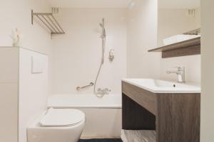 a white bathroom with a toilet and a sink at Hotel karel de stoute in Bruges