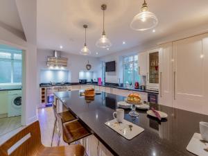 a large kitchen with a large island in the middle at Clarion Lodge Cottage Ilkley in Menston