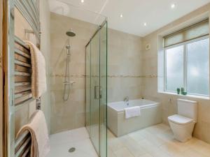 a bathroom with a shower and a toilet and a sink at Clarion Lodge Cottage Ilkley in Menston