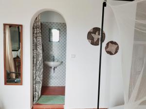 a bathroom with a sink and a mirror at Maison d'hôtes Keur Racine in Cap Skirring