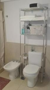 y baño con aseo blanco y lavamanos. en Hermoso Departamento SABOR MALBEC . cochera, seguridad privada, cerca del centro en Godoy Cruz