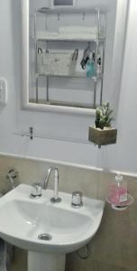 y baño con lavabo blanco y espejo. en Hermoso Departamento SABOR MALBEC . cochera, seguridad privada, cerca del centro en Godoy Cruz