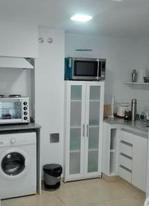 y cocina con microondas y lavadora. en Hermoso Departamento SABOR MALBEC . cochera, seguridad privada, cerca del centro en Godoy Cruz