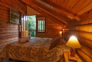 1 dormitorio con 1 cama en una cabaña de madera en Cabañas Huincul en Villa Gesell