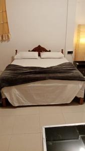 a bedroom with a large bed with white sheets at Air Vision 98 in Katunayaka