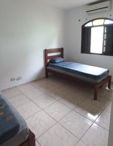 a small room with a bed and a window at Casa Perto da Praia Caraguatatuba in Caraguatatuba