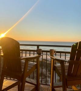 two chairs sitting on a deck looking out at the ocean at Direct Ocean Front 3BR/2BA Dog Friendly in Myrtle Beach