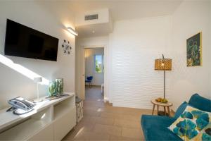 Una sala de estar con un sofá azul y un televisor en Tenuta Rocci Cerasoli, en Parabita