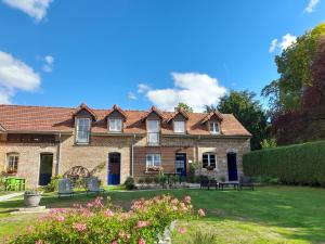 a large brick house with blue doors and a yard at Gîtes "Aux Charmes de la Baie" labellisés 3 clévacances avec parking et terrain clos in Buigny-Saint-Maclou
