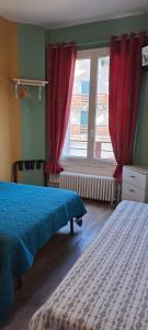 a bedroom with two beds and a window with red curtains at Les 4 Montagnes in Villard-de-Lans