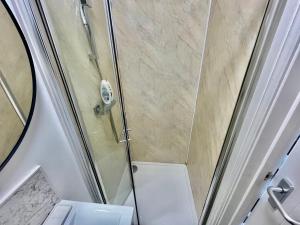 a bathroom with a shower with a toilet and a sink at Lovely self contained studio now available in London