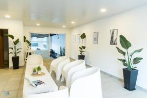 een woonkamer met witte stoelen en een tafel bij APART HOTEL RIBERA DEL BARADERO pileta climatizada in Baradero