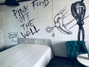 1 dormitorio con 1 cama y una pared con graffiti en Квартира в стиле лофт для гостей Караганды en Karagandá